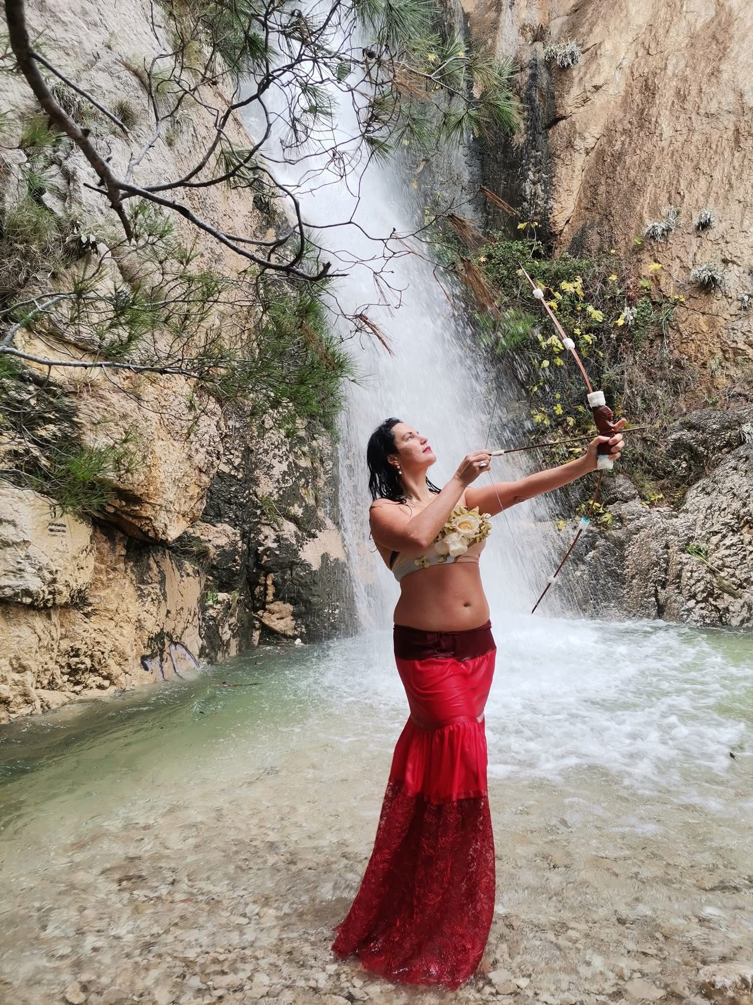 Daniela “Didi” Čolić in red dress near a waterfall